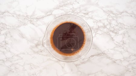 Téléchargez les photos : Pose plate. Pas à pas. Préparation de ganache au chocolat dans un bol à mélanger en verre. - en image libre de droit