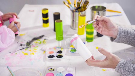 Photo for Kids papercraft. Painting empty toilet paper rolls with acrylic paint to create paper bugs. - Royalty Free Image