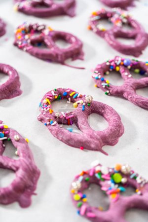 Foto de Decorating chocolate-dipped pretzels twists with chocolate mermaid tails. - Imagen libre de derechos