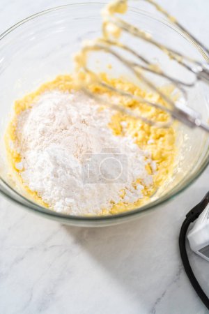 Photo for Mixing ingredients in a large glass mixing bowl to make the cream cheese filling for bundt cake. - Royalty Free Image