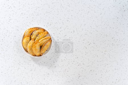 Foto de Acostado. Empanadas dulces recién horneadas con arándanos en el mostrador de la cocina. - Imagen libre de derechos