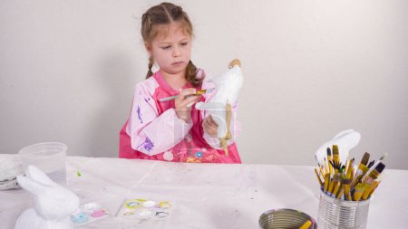Photo for Little girl painting paper mache figurine at homeschooling art class. - Royalty Free Image