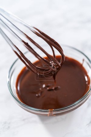 Téléchargez les photos : Préparation de ganache au chocolat dans un bol à mélanger en verre. - en image libre de droit
