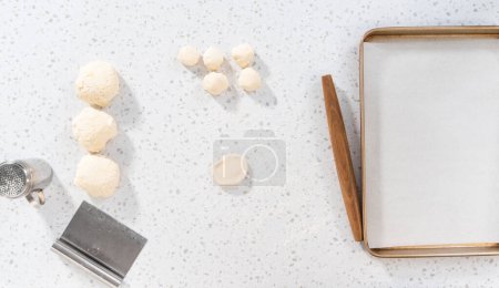 Photo for Flat lay. Rolling bread dough with a french rolling pin to bake naan dippers. - Royalty Free Image
