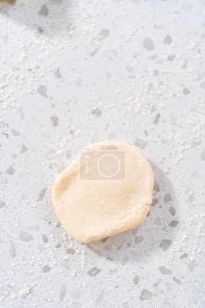 Photo for Rolling bread dough with a french rolling pin to bake naan dippers. - Royalty Free Image