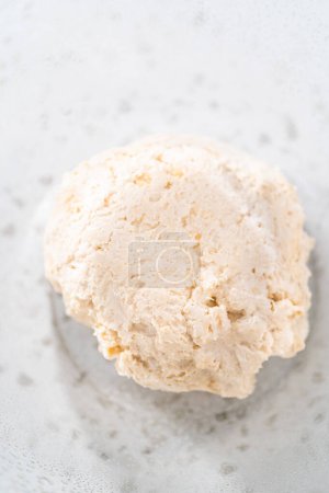 Photo for Rising dough in a glass mixing bowl to bake naan dippers. - Royalty Free Image