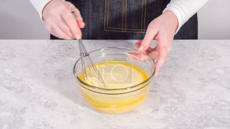 Téléchargez les photos : Pas à pas. Mélanger les ingrédients dans un bol de mélange en verre pour préparer des crêpes à la banane à la noix de coco. - en image libre de droit