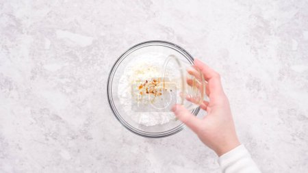 Photo for Flat lay. Step by step. Mixing ingredients in a glass mixing bowl to prepare cream cheese frosting. - Royalty Free Image