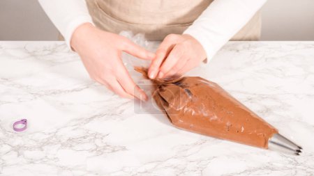 Téléchargez les photos : Pas à pas. glaçage ganache chocolat dans un sac de tuyauterie avec une pointe en métal. - en image libre de droit