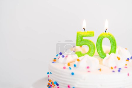 Kleine Geburtstagstorte zum 50. Geburtstag auf weißem Kuchenteller.