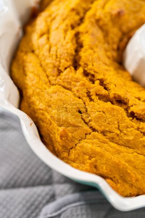 Photo for Cooling freshly baked pumpkin bunt cake on a kitchen counter. - Royalty Free Image