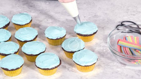 Foto de Paso a paso. Decoración de cupcakes de chocolate con glaseado de crema de mantequilla y dulces de arco iris. - Imagen libre de derechos