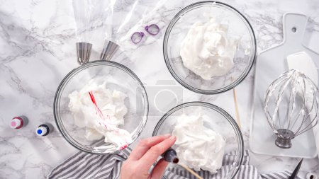 Photo for Step by step. Flat lay. Mixing food coloring into the meringue to bake unicorn meringue cookies. - Royalty Free Image