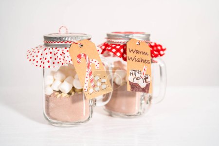 Foto de Hacer mezcla casera de chocolate caliente en tarro de albañil para regalo de comida de Navidad. - Imagen libre de derechos