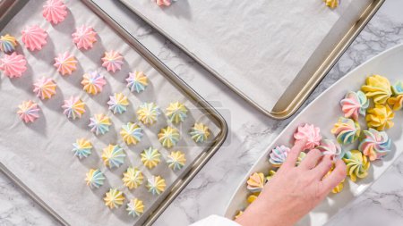 Photo for Step by step. Flat lay. Freshly baked unicorn meringue cookies on a baking sheet with a parchment paper. - Royalty Free Image