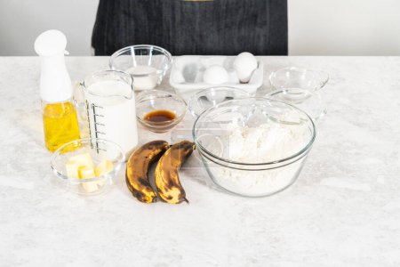 Foto de Ingredientes medidos en cuencos de vidrio para preparar panqueques de plátano de coco para el desayuno. - Imagen libre de derechos