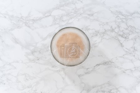 Téléchargez les photos : Activer la levure sèche dans un bol à mélanger en verre pour faire cuire le mini pain de Pâques kulich. - en image libre de droit