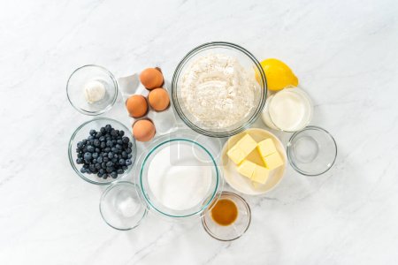 Photo for Flat lay. Measured ingredients in glass mixing bowls to bake lemon blueberry bundt cake. - Royalty Free Image
