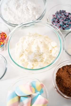 Foto de Ingredientes medidos en cuencos de vidrio para hacer una mezcla de chocolate caliente unicornio. - Imagen libre de derechos