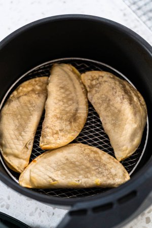 Photo for Frying sweet cherry empanadas in the air fryer. - Royalty Free Image