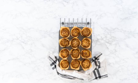 Photo for Flat lay. Cooling freshly baked banana oatmeal muffins on a kitchen counter. - Royalty Free Image