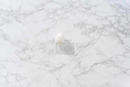 Photo for Peeling hard-boiled eggs at the marble kitchen counter. - Royalty Free Image