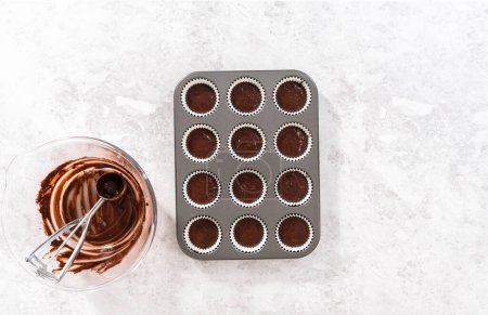 Photo for Flat lay. Scooping chocolate cupcake dough into the cupcake liners. - Royalty Free Image