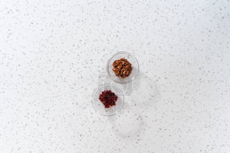 Foto de Acostado. Ingredientes medidos en cuencos de vidrio para hacer chocolate blanco mermelada de nuez de arándano. - Imagen libre de derechos
