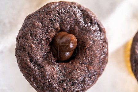 Téléchargez les photos : Remplir de cupcakes au chocolat avec de la ganache au chocolat. - en image libre de droit