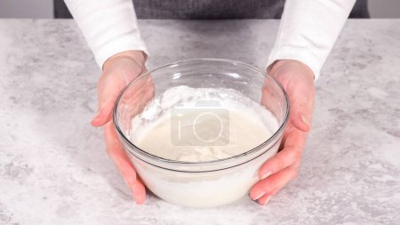 Téléchargez les photos : Pas à pas. Mélanger les ingrédients dans un bol de mélange en verre pour préparer le glaçage au fromage à la crème. - en image libre de droit