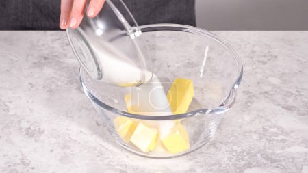 Photo for Step by step. Mixing ingredients in a glass mixing bowl to prepare red velvet bundt cake. - Royalty Free Image