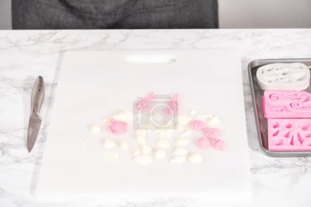 Photo for Removing mermaid-themed chocolate from the silicone molds to the white cutting board. - Royalty Free Image