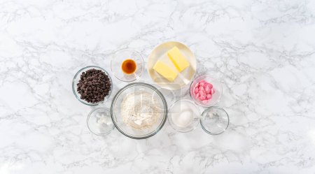 Foto de Acostado. Ingredientes medidos en tazones de vidrio para hornear galletas de shortbread en forma de panda con glaseado de chocolate. - Imagen libre de derechos
