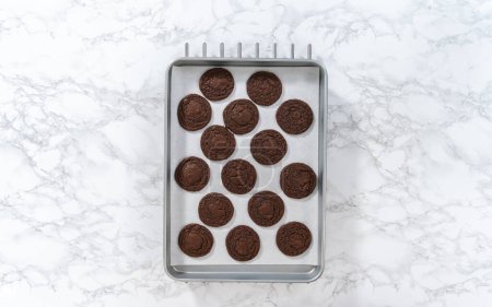 Téléchargez les photos : Pose plate. Refroidissement des biscuits au chocolat fraîchement cuits avec des cœurs de chocolat pour la Saint-Valentin sur un comptoir de cuisine. - en image libre de droit