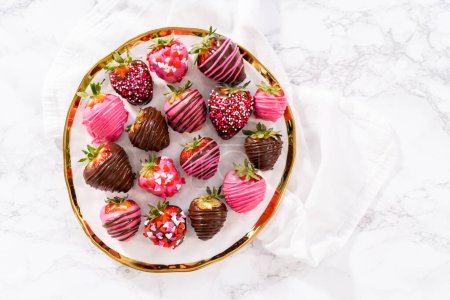Photo for Gourmet chocolate-covered strawberries decorated with chocolate drizzles and sprinkles on a white plate. - Royalty Free Image