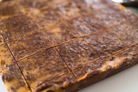 Téléchargez les photos : Marquage de caramel au beurre d'arachide au chocolat pour découper en petits morceaux. - en image libre de droit