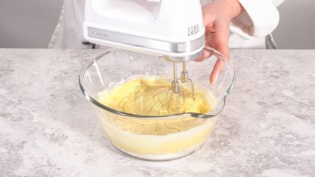 Paso a paso. Mezclar los ingredientes en un tazón de vidrio para hornear pastel de paquete funfettti.