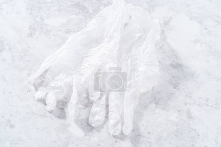 Téléchargez les photos : Paire de gants en vinyle blanc jetables sur le comptoir. - en image libre de droit