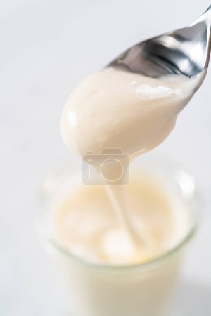 Photo for Cream cheese glaze in small glass jat. - Royalty Free Image