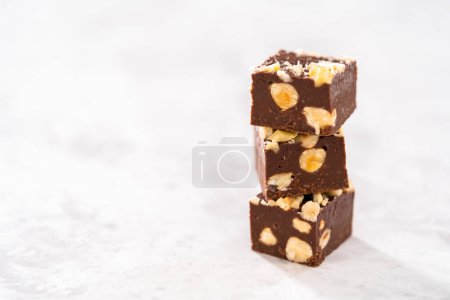 Foto de Piezas cuadradas de chocolate caseras de avellana apiladas en el mostrador de la cocina. - Imagen libre de derechos