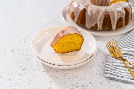 Téléchargez les photos : Gâteau de lapin à la vanille tranché avec un glaçage blanc sur une assiette blanche. - en image libre de droit