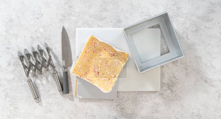 Téléchargez les photos : Flat lay. Removing candy cane fudge from a square cheesecake pan lined with parchment. - en image libre de droit
