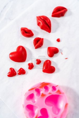 Foto de Dusting chocolate lips and heart-shaped chocolates with editable glitter for Valentines Day. - Imagen libre de derechos