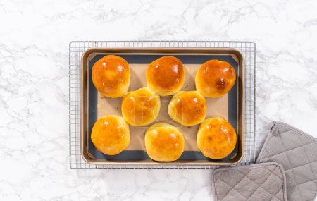 Flat lay. Freshly baked brioche buns on a baking sheet with a silicone mat.