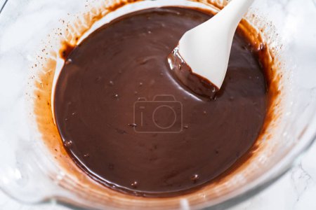 Préparation de ganache au chocolat dans un bol à mélanger en verre.