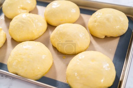 Photo for Rising brioche dough on a baking sheet with a silicone mat. - Royalty Free Image