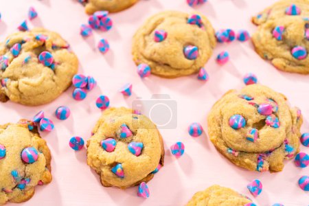 Téléchargez les photos : Biscuits aux pépites de chocolat de licorne fraîchement cuits avec des pépites de chocolat arc-en-ciel sur le comptoir. - en image libre de droit