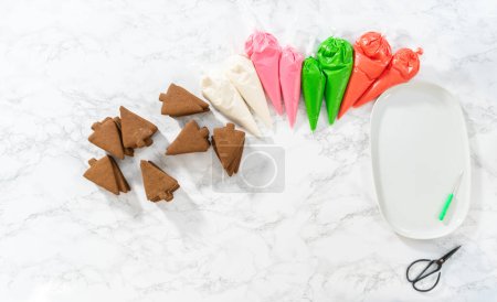 Photo for Flat lay. Decorating Christmas gingerbread cookies with royal icing. - Royalty Free Image