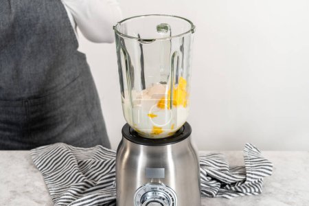 Photo for Mixing ingredients in kitchen blender to prepare mango boba smoothie. - Royalty Free Image