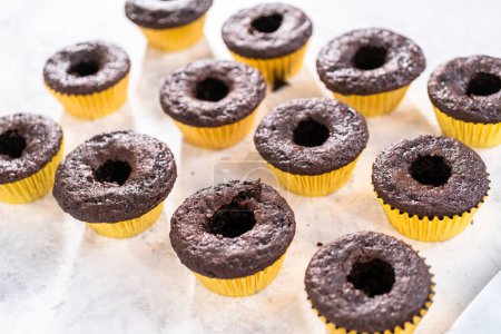 Photo for Filling in chocolate cupcakes with chocolate ganache. - Royalty Free Image